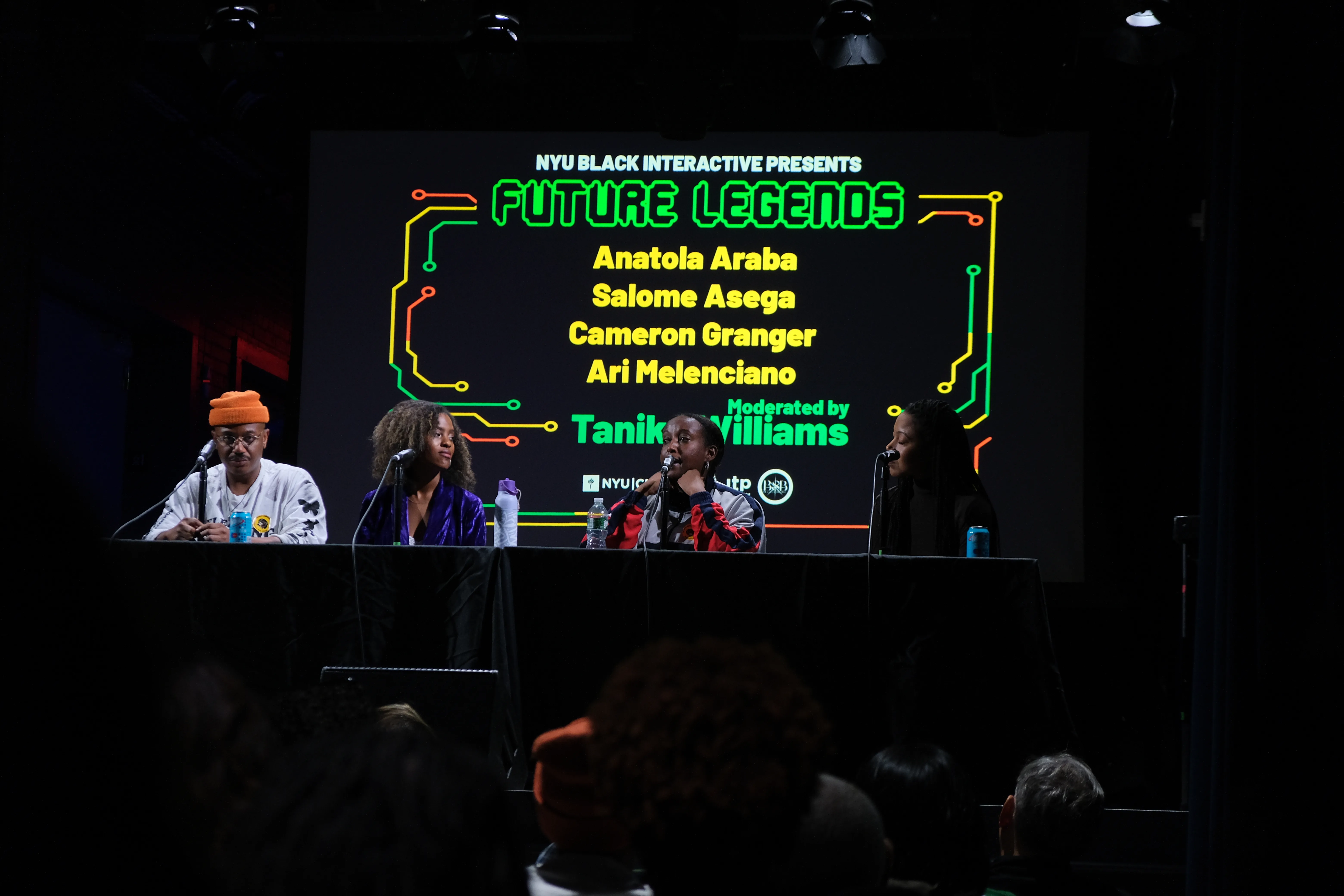 Panelists on stage at the Future Legends event series, beneath a screen displaying the event title and panelist names